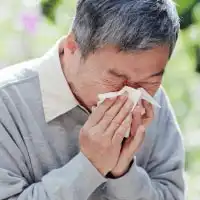 photo of sennior man blowing nose